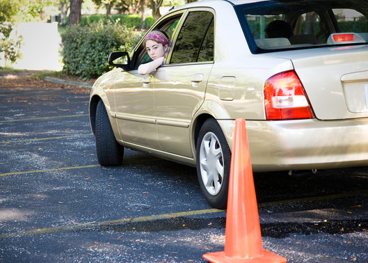 Teen driver backs up, doing the parking portion of her driving test.